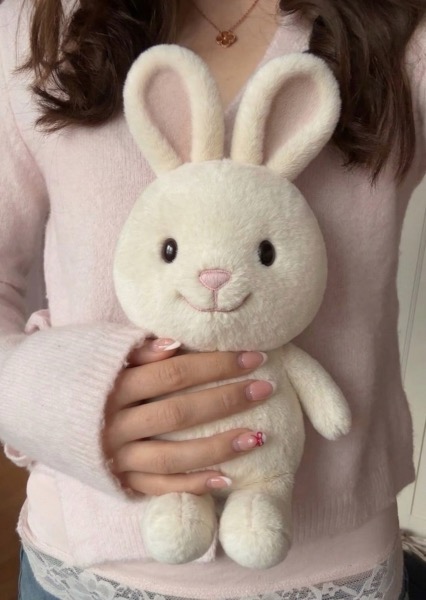 Soft white bunny plush held in arms, Hvile's brand companion